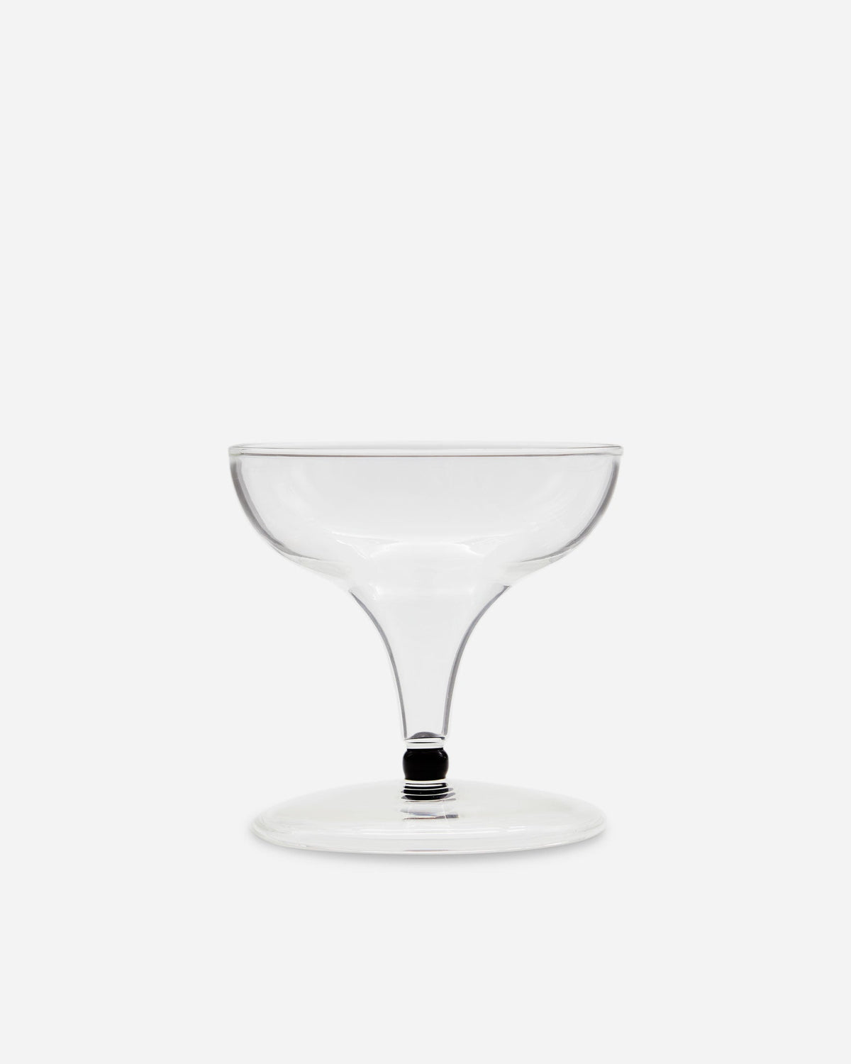 Single handblown coupe glass with a wide bowl and short dark-banded stem on a pale gray background