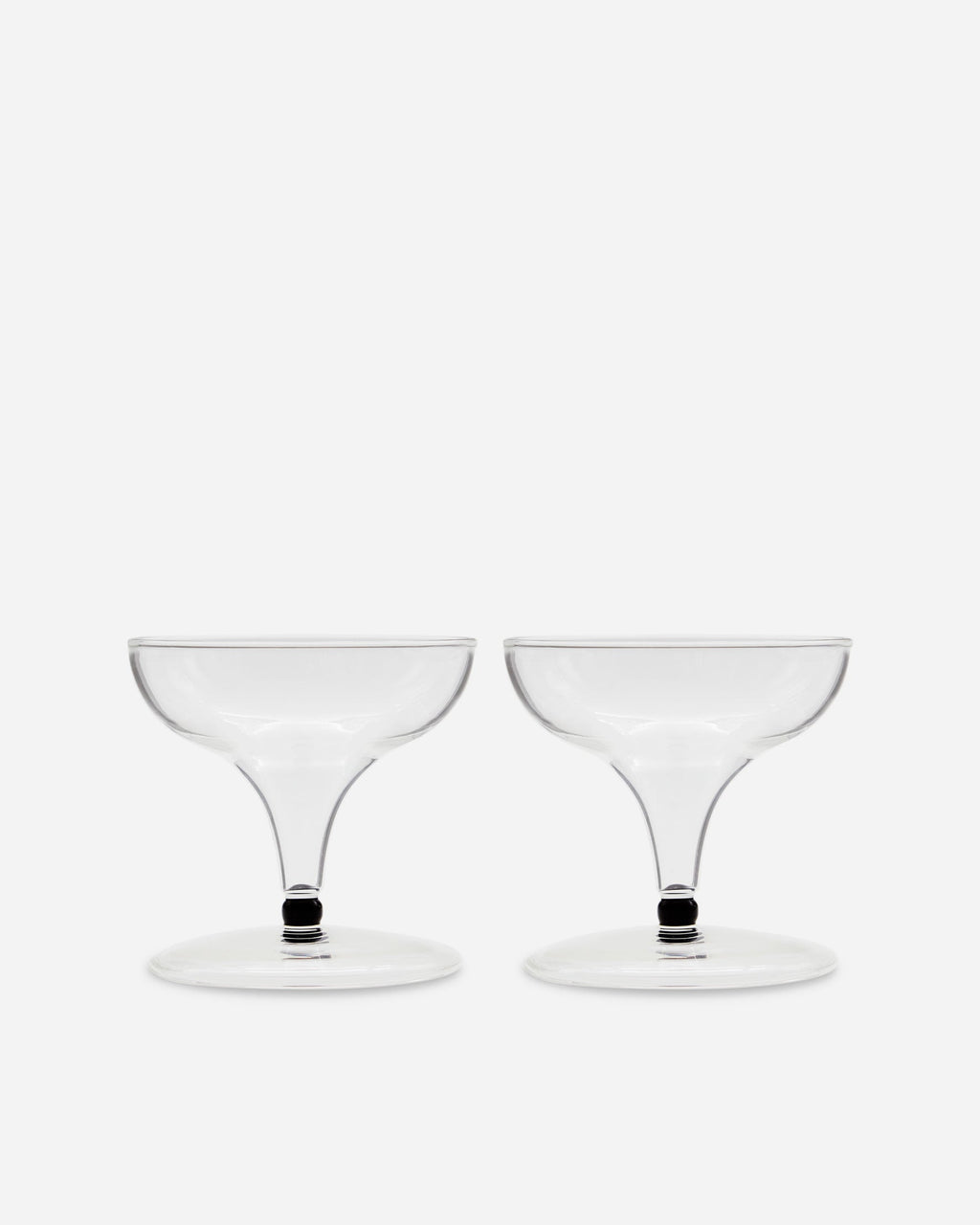 Pair of handblown coupe glasses with short stems and a dark accent band on a pale gray background
