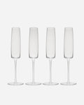 Four handblown crystalline champagne flutes with tall straight bowls and slender stems on a pale grey background