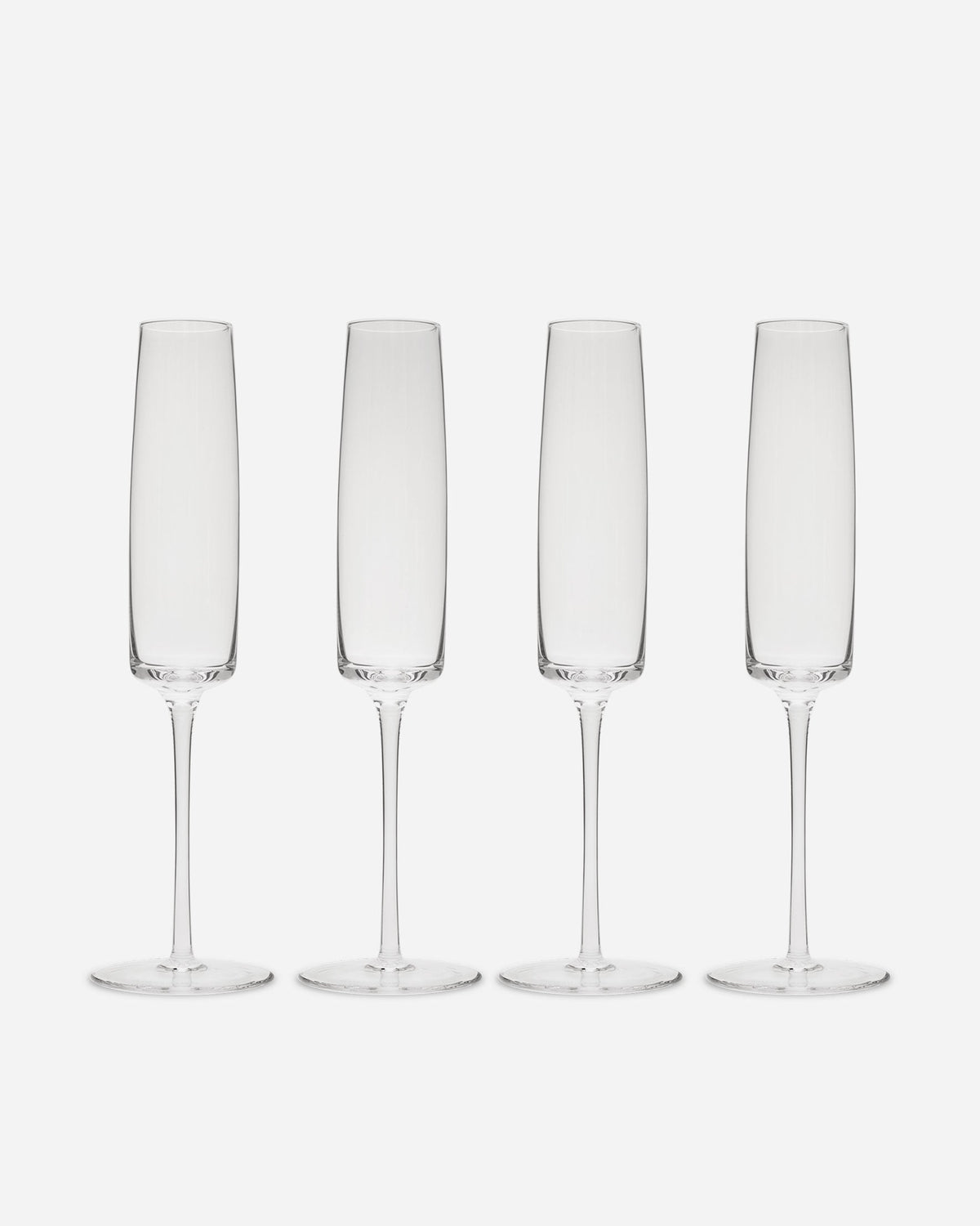Four handblown crystalline champagne flutes with tall straight bowls and slender stems on a pale grey background