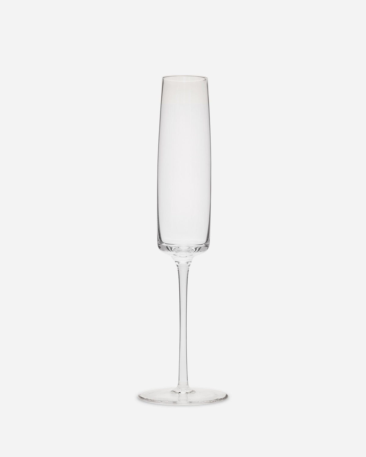 Single handblown champagne flute in clear lead-free crystalline glass with a long thin stem on a pale grey ground