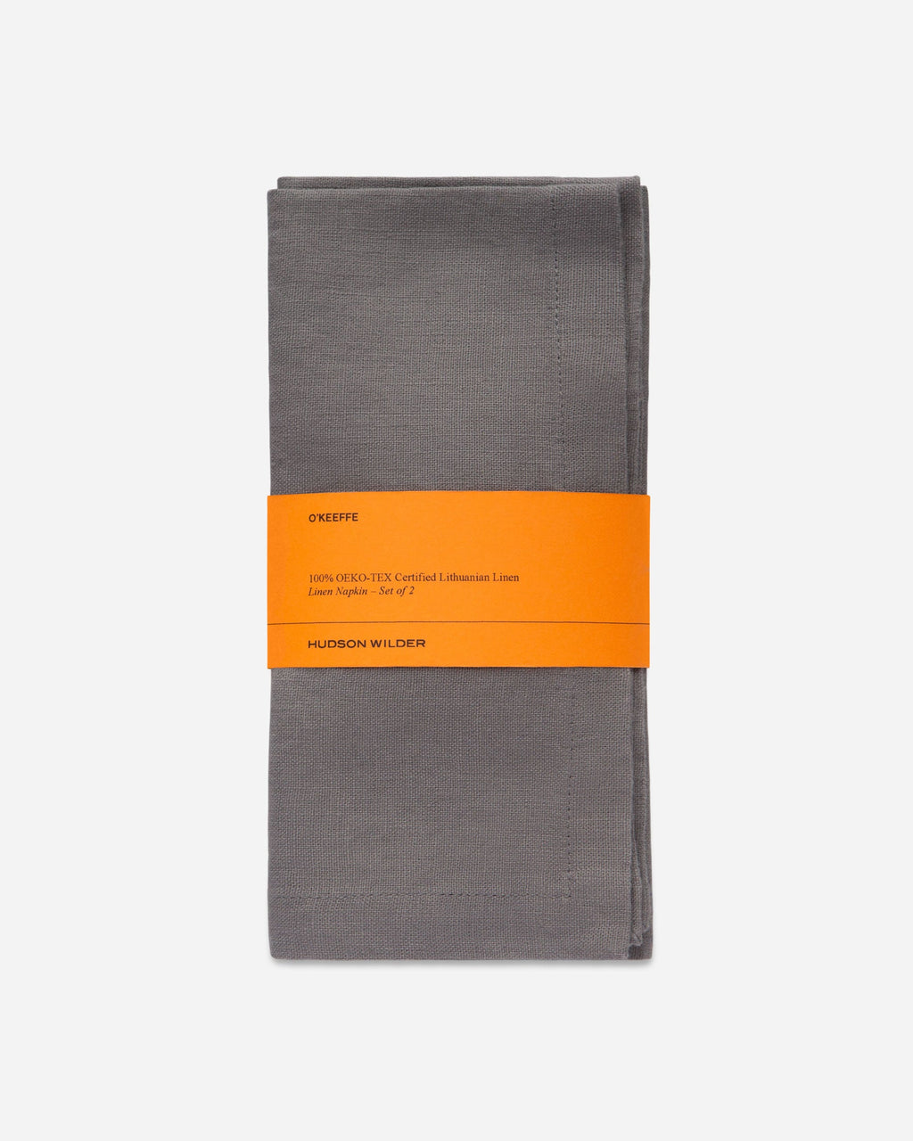 Folded slate gray linen napkin set wrapped with an orange paper band, shown on a pale gray background