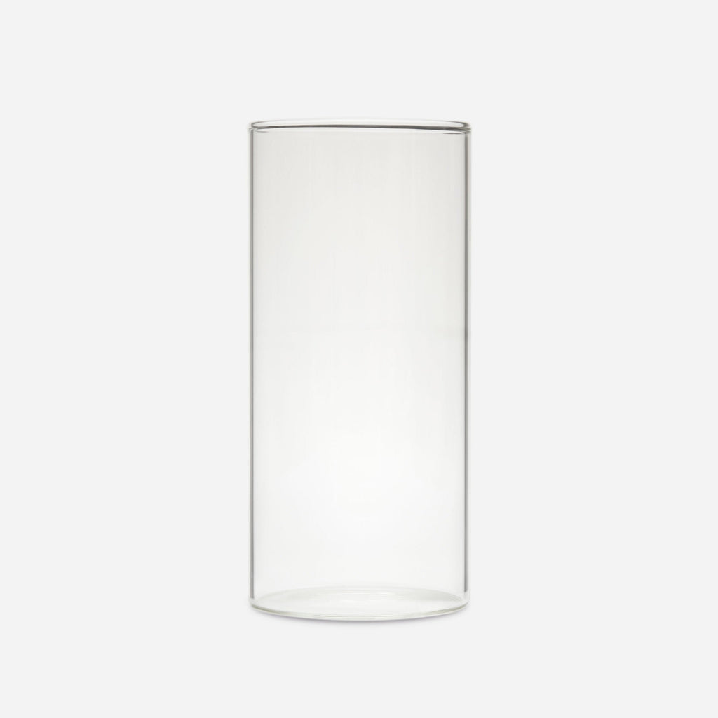 Tall clear handblown glass cylinder vase with straight sides, shown empty on a pale gray background