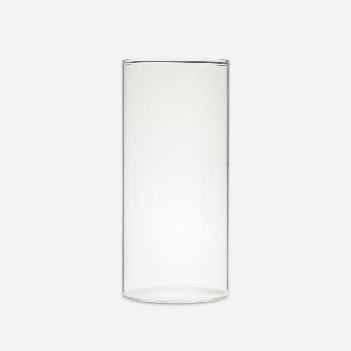 Tall clear handblown glass cylinder vase with straight sides, shown empty on a pale gray background