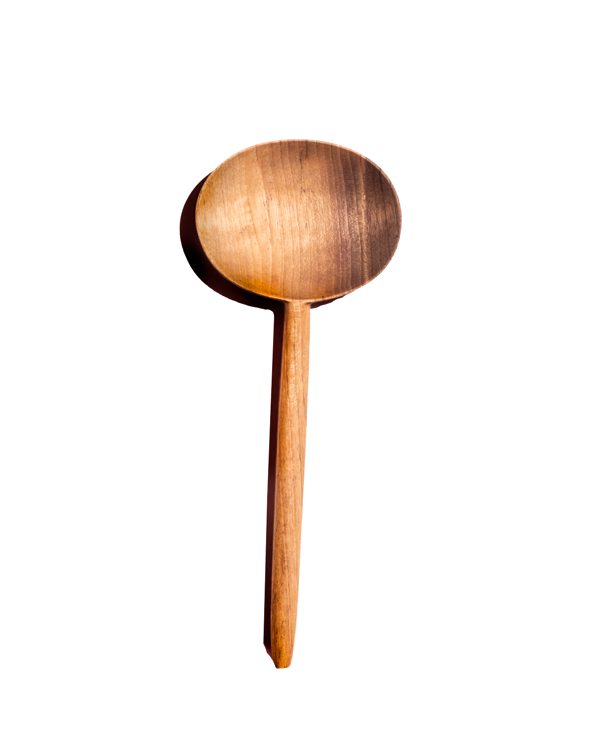 Single carved walnut oval serving spoon with warm honey-colored grain, shown from above against black