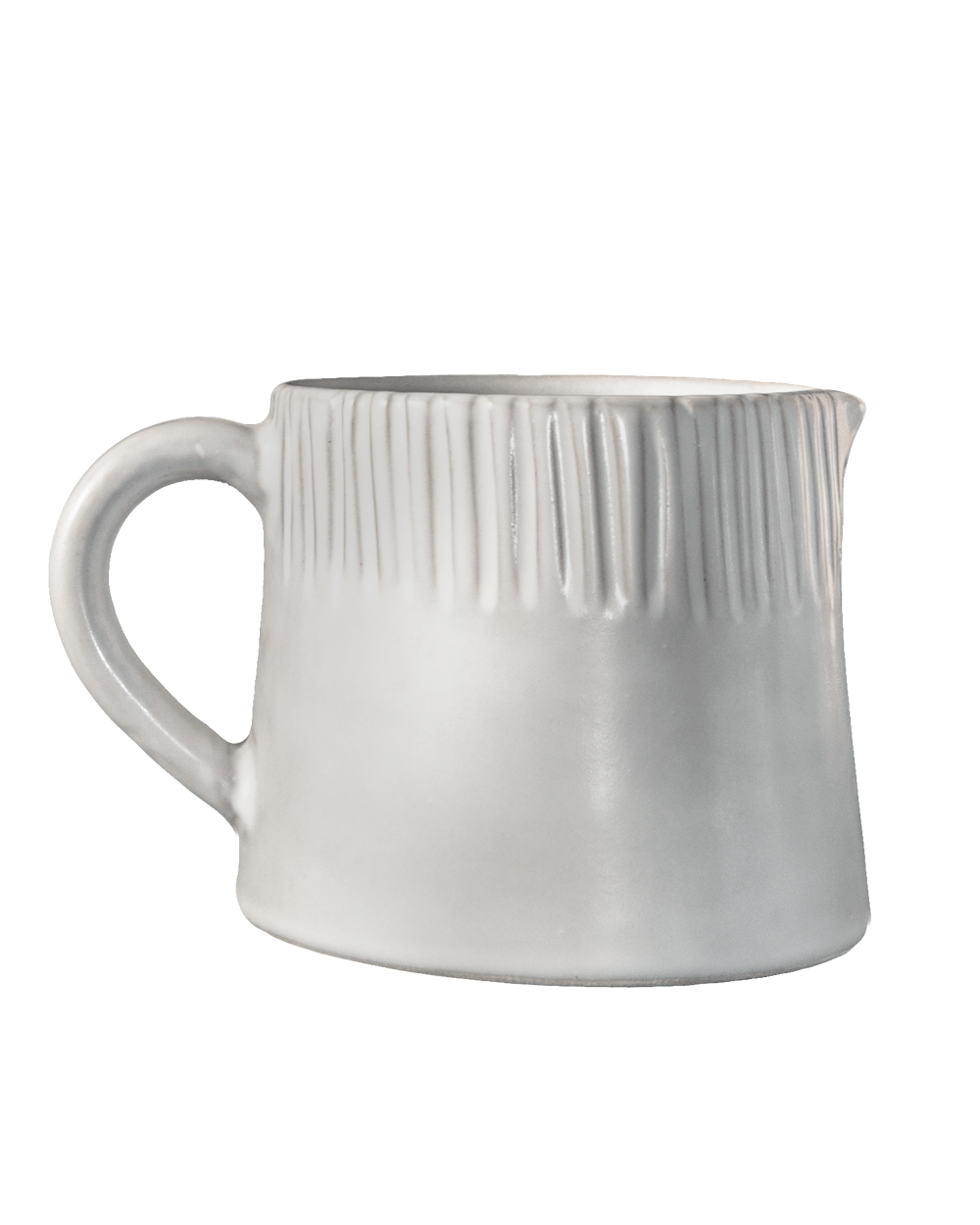 Close view of a carved matte white ceramic pitcher showing its line detail on green