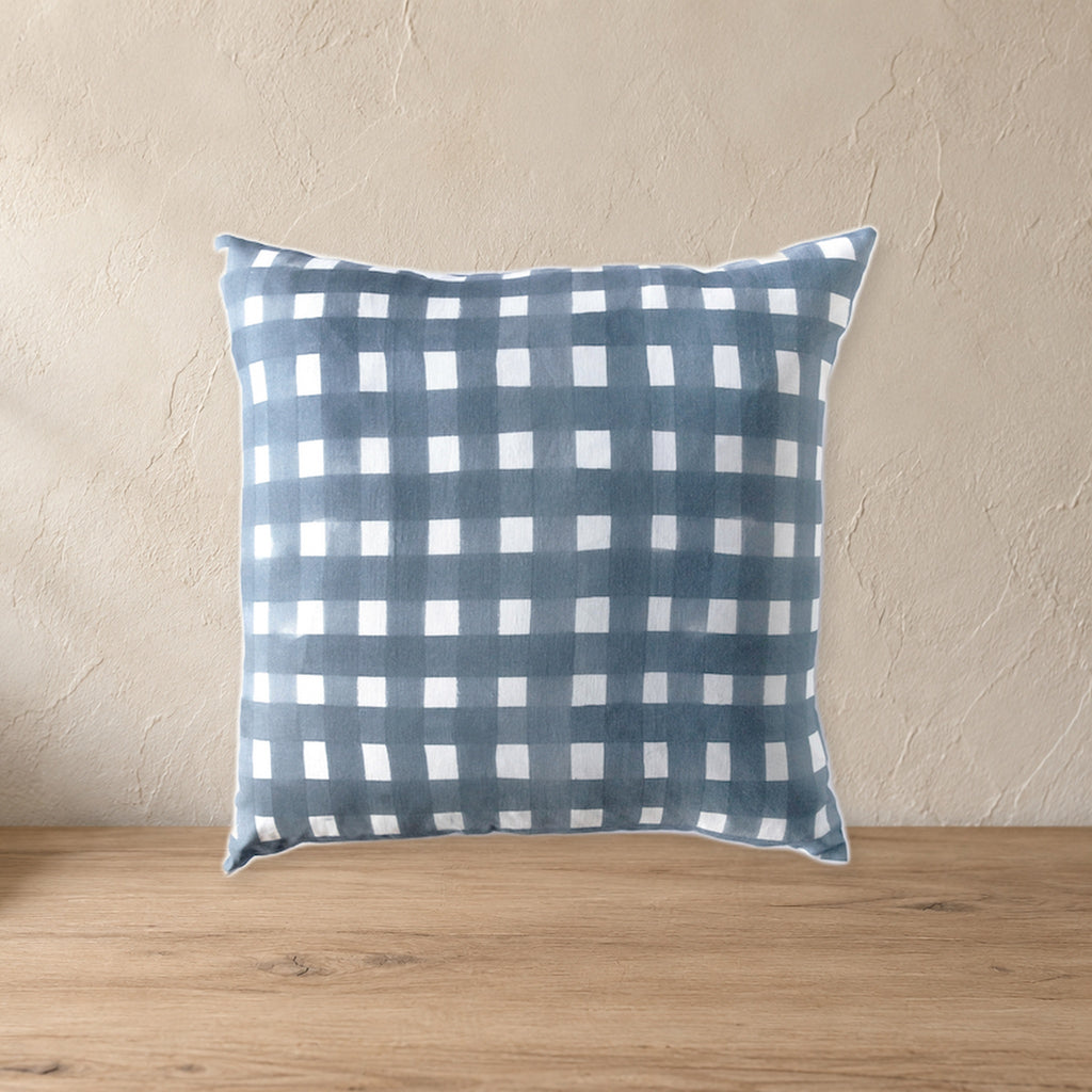 Blue Cross-Hatch Linen Throw Pillow on a pale wood console against a plaster wall.