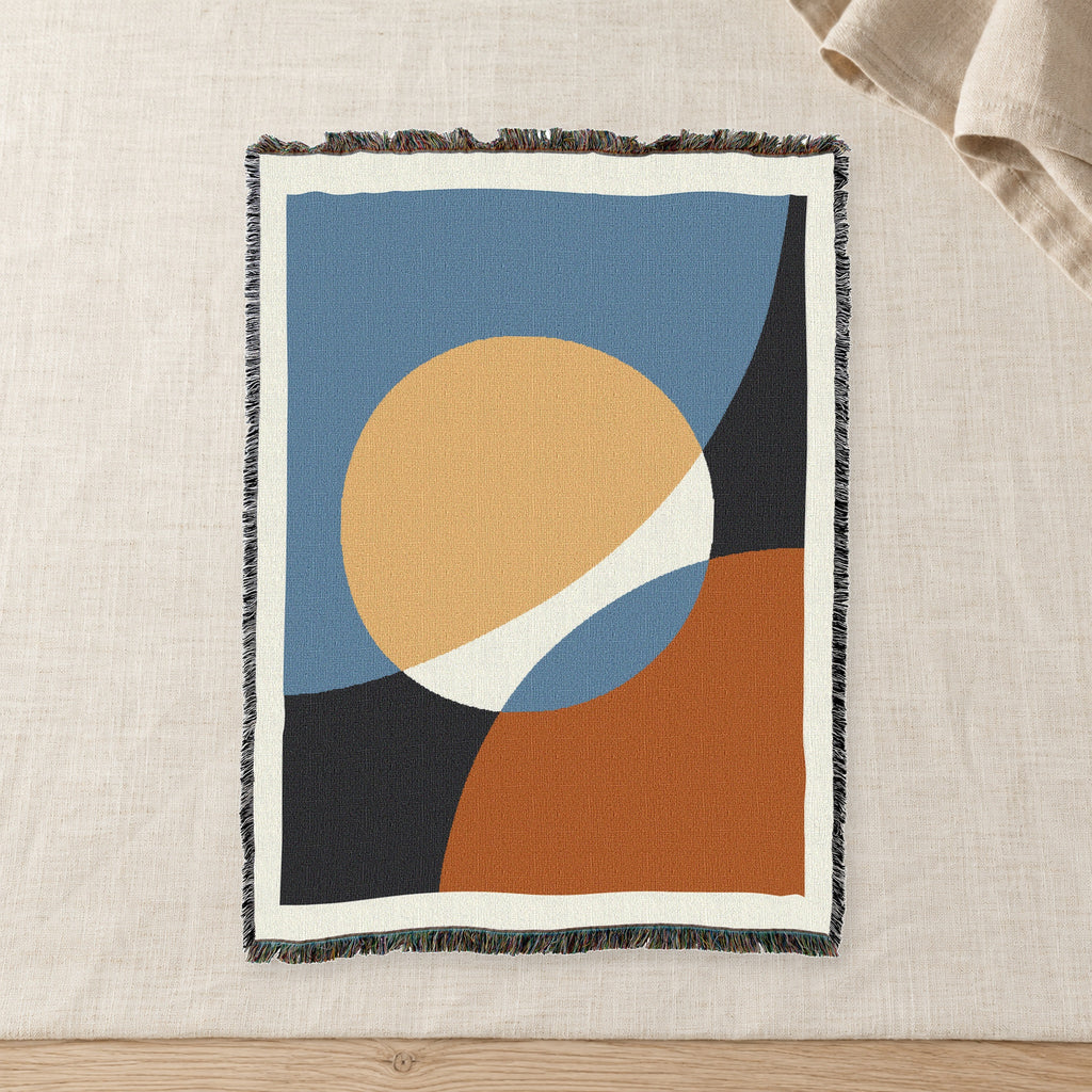 Clay Sun Abstract Woven Cotton Throw on raw linen with a folded napkin.