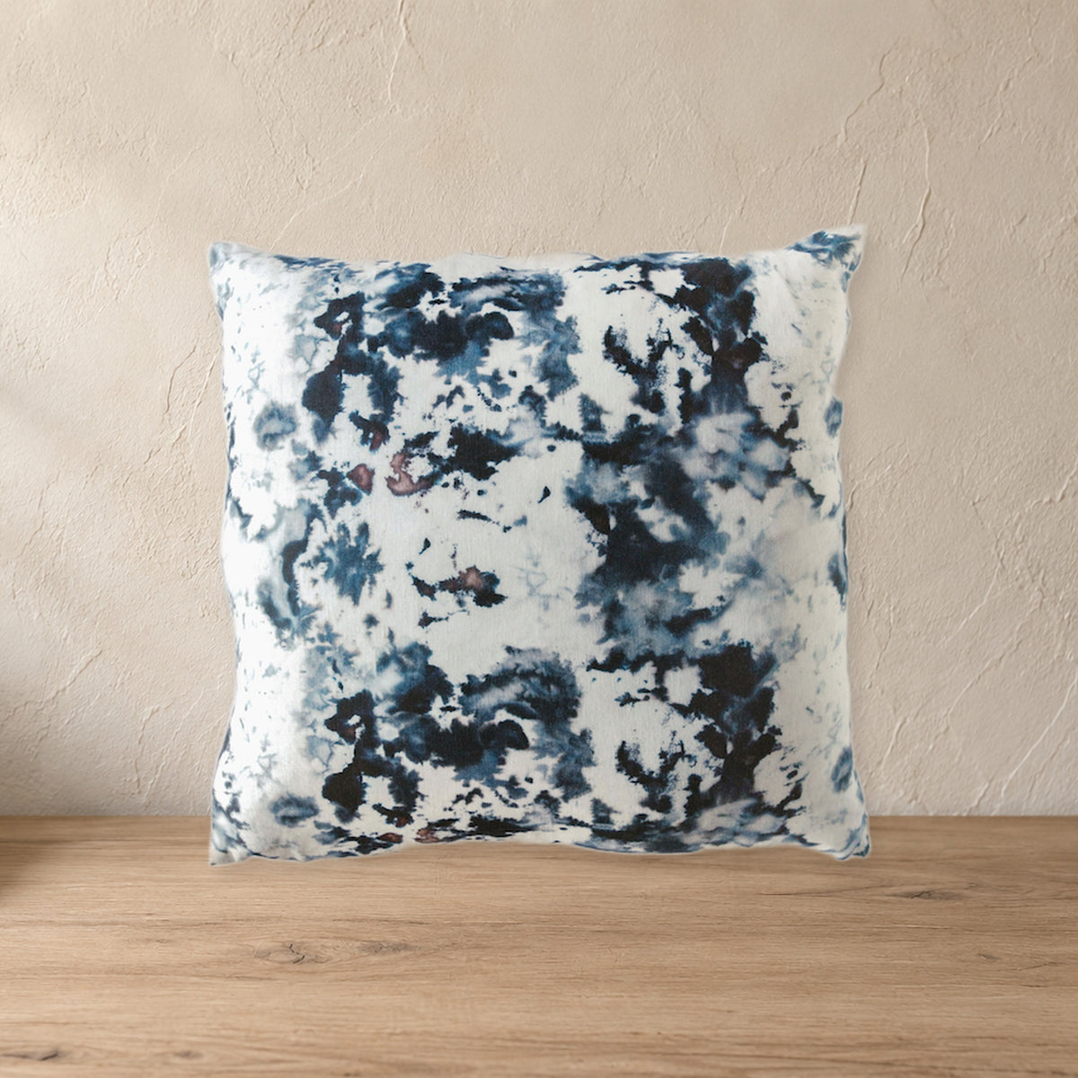 Hand-Painted Grey Marble Linen Throw Pillow on a pale wood console against a plaster wall.