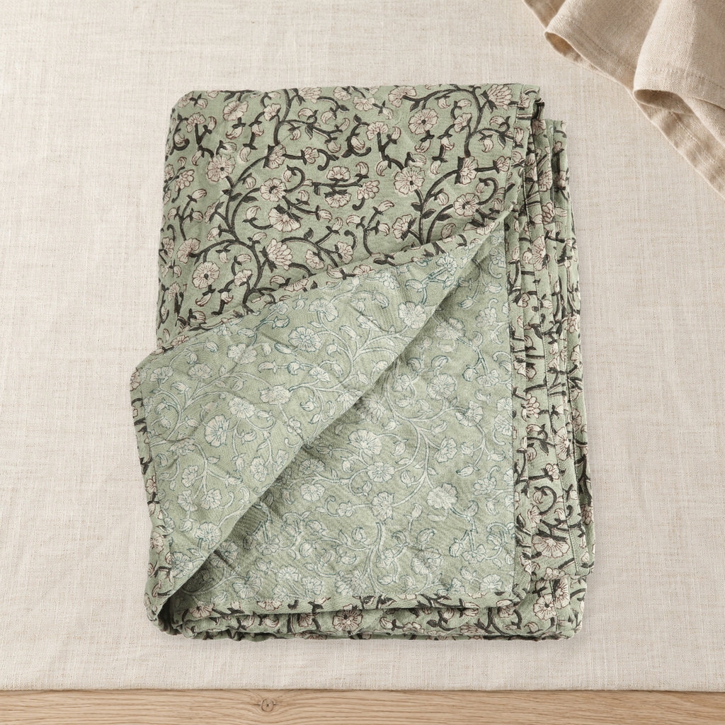 Keya Linen Block Print Quilted Coverlet on raw linen with a folded napkin.