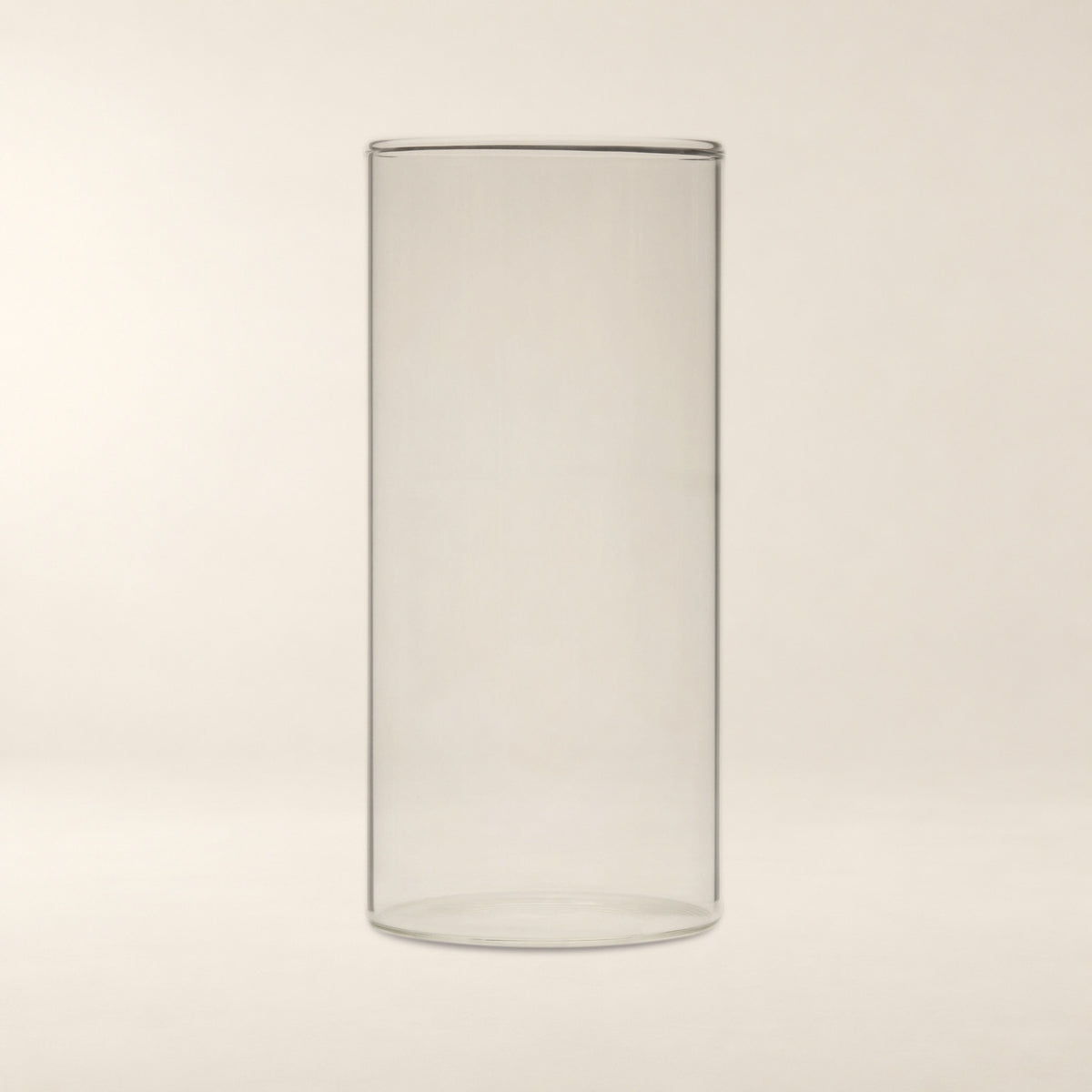 Sora Handblown Glass Cylinder Vase, 7 in on a warm bone background.