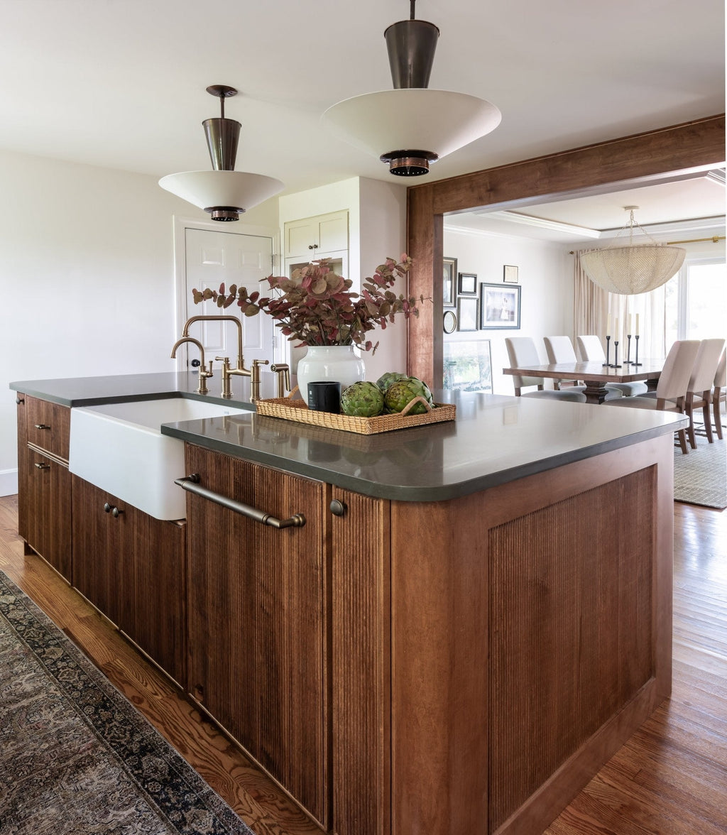Kitchen with a wood island and white counters where a white glazed terracotta jar sits in the room